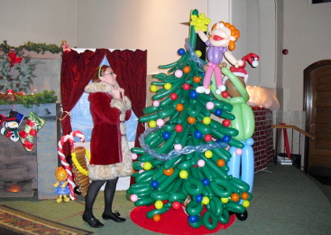 Janice dressed as Mrs. Claus next to a balloon tree